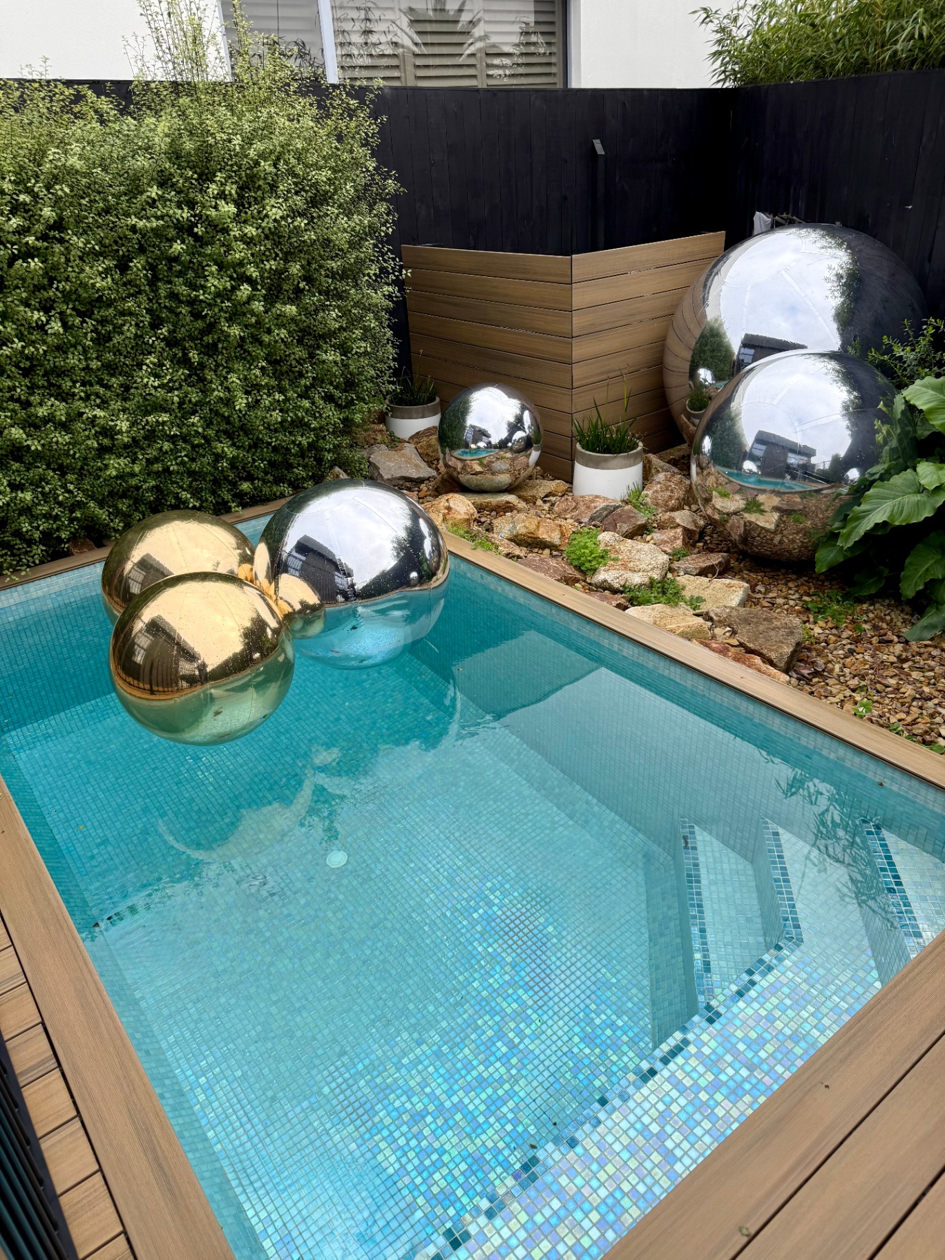 Gold and silver spheres floating in a private pool