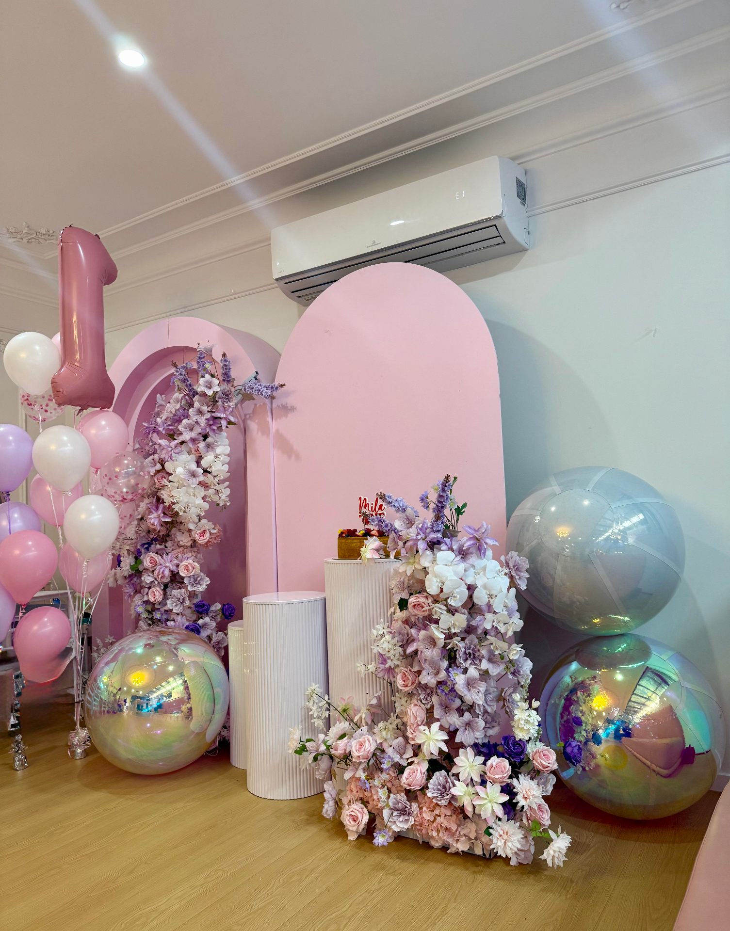 Mirror spheres with pastel florals at a first birthday party