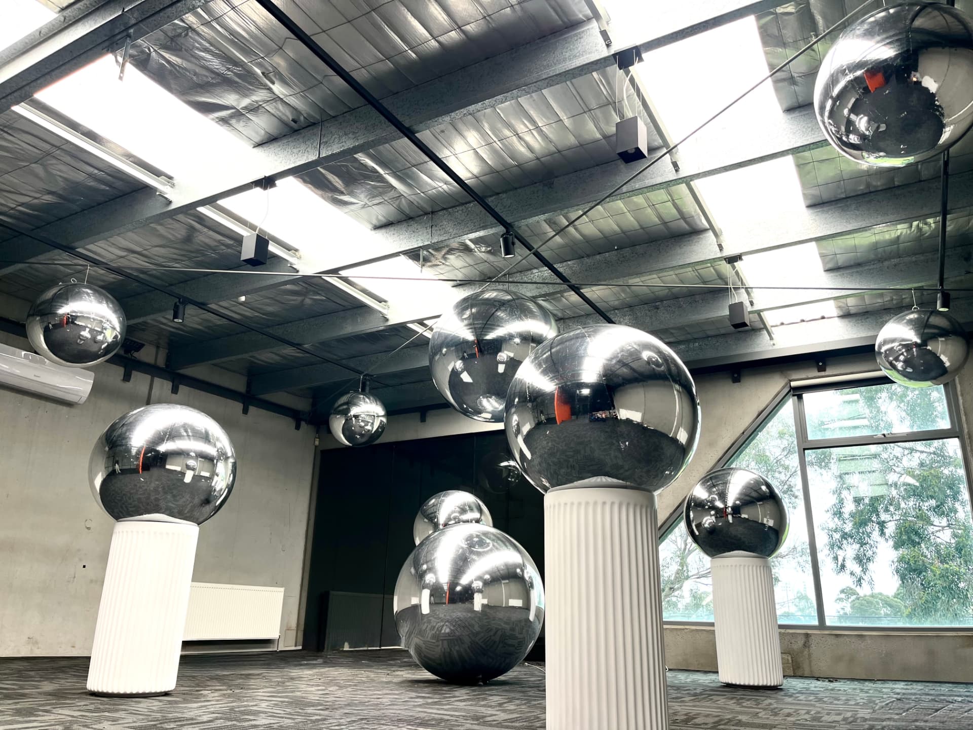 Reflective inflatable spheres in a modern venue space